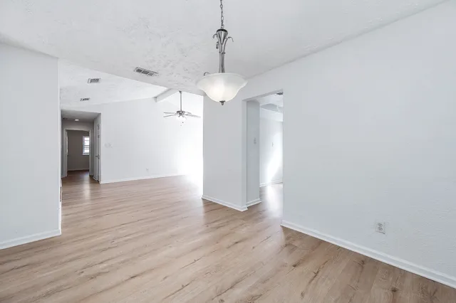 a view of a room with wooden floor and ceiling fan