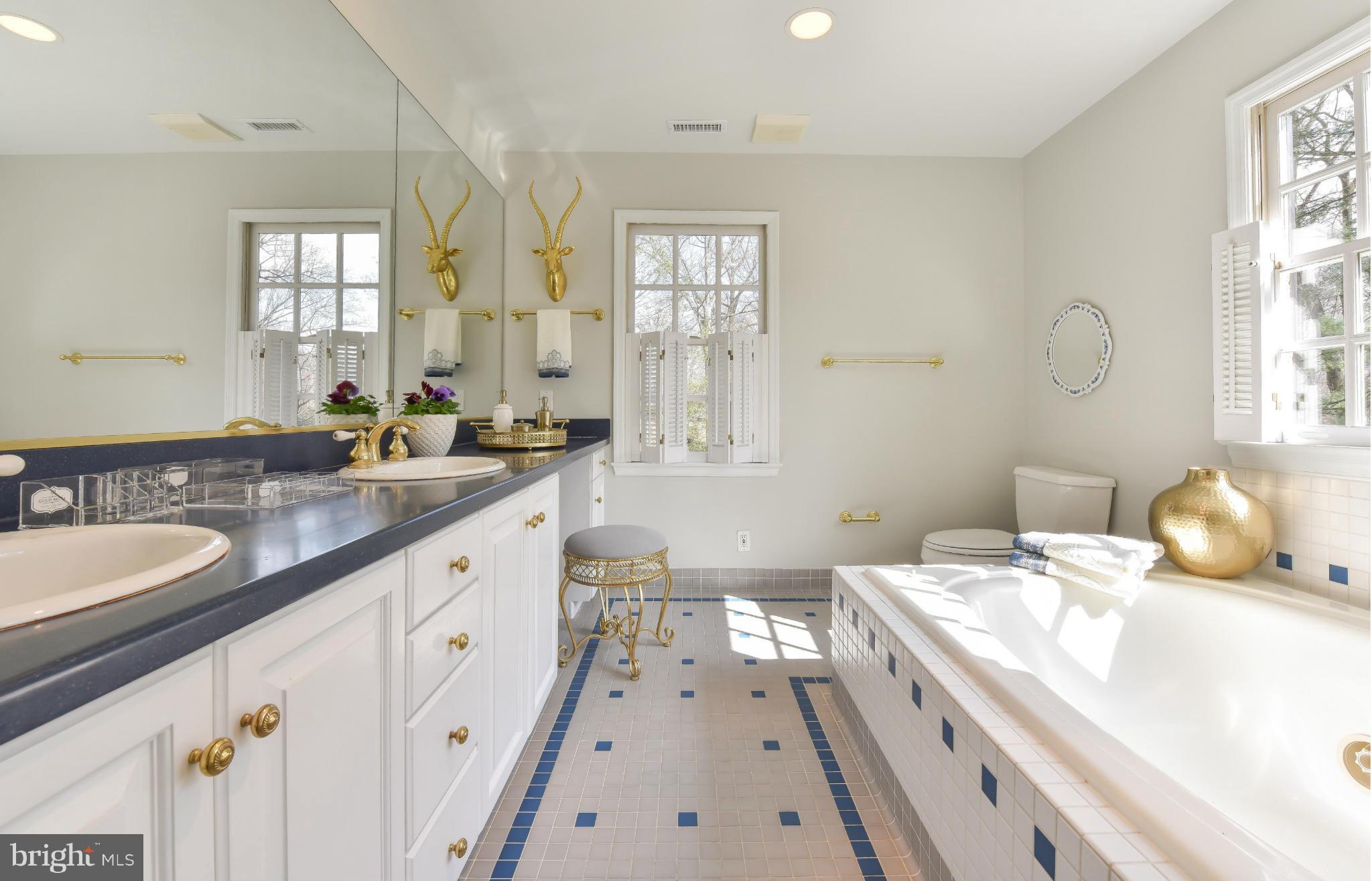 7704 Burford Drive McLean, VA 22102 - Photo 19 of 30 a spacious bathroom with double vanity sinks a mirror a lamp and window