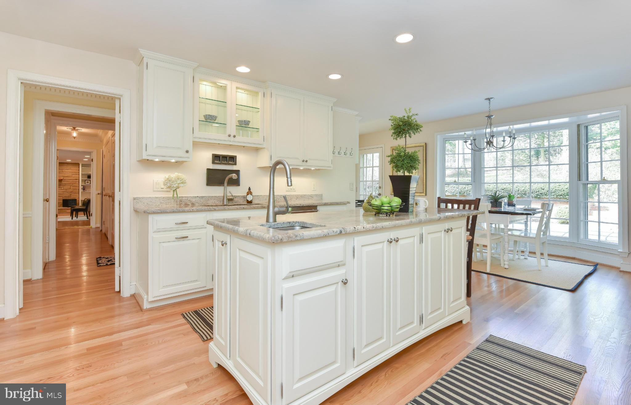 7704 Burford Drive McLean, VA 22102 - Photo 7 of 30 a kitchen with white cabinets a sink dishwasher and a stove with wooden floor
