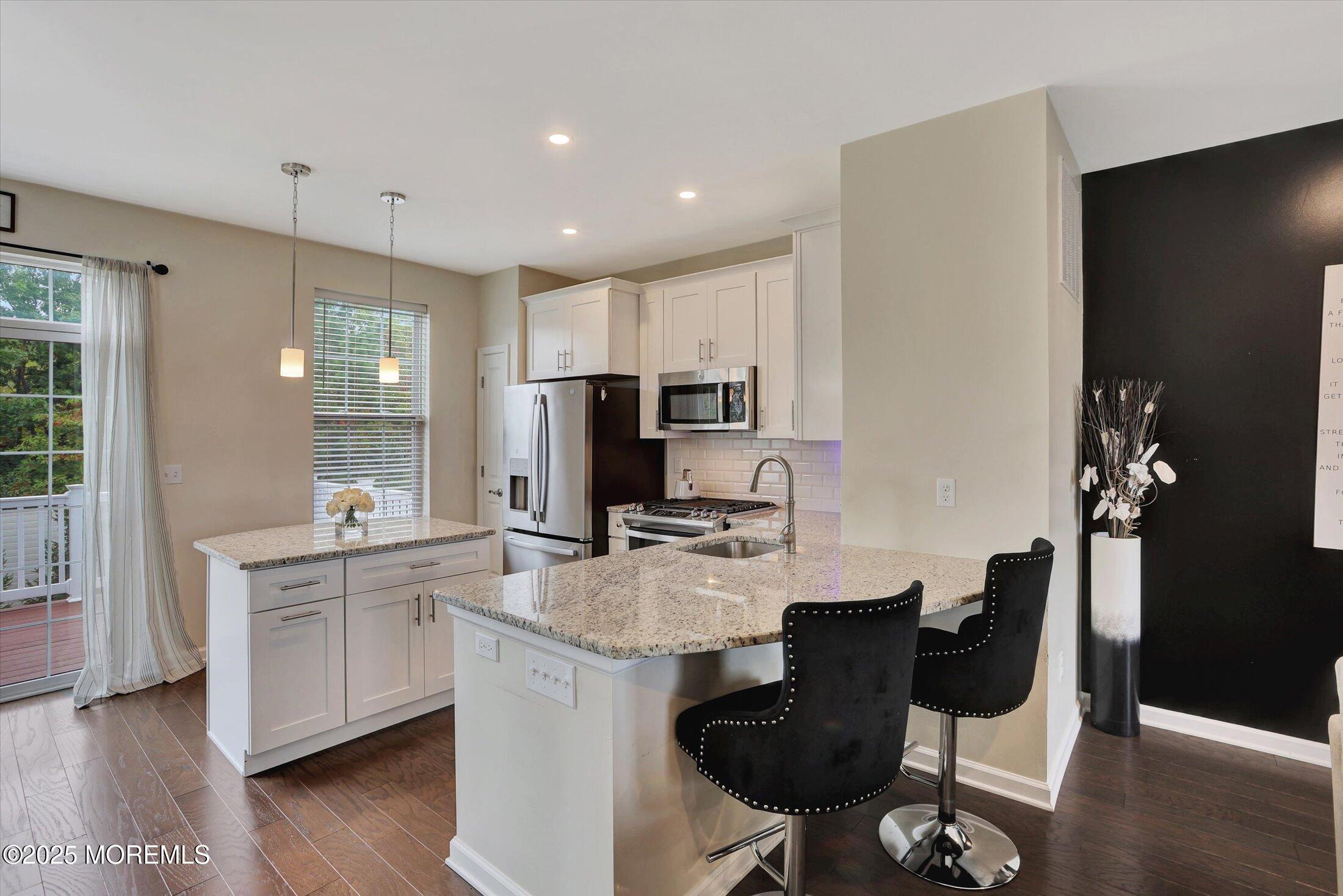 303 Prosper Way, Unit 203 Brick, NJ 08723 - Photo 11 of 36 a kitchen with a sink cabinets and wooden floor