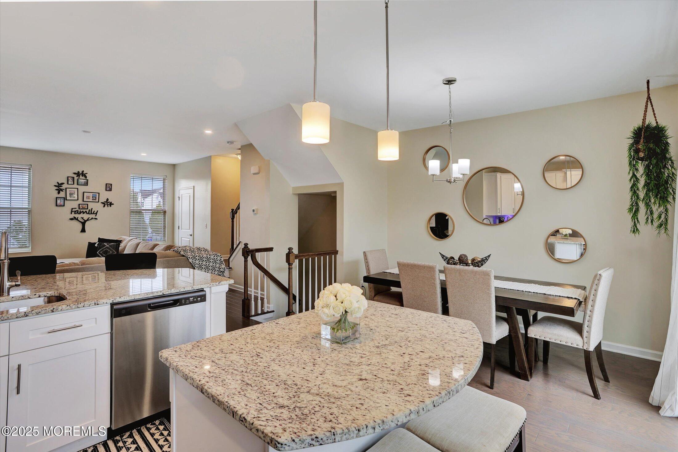 303 Prosper Way, Unit 203 Brick, NJ 08723 - Photo 14 of 36 a large kitchen with kitchen island a dining table and a fireplace