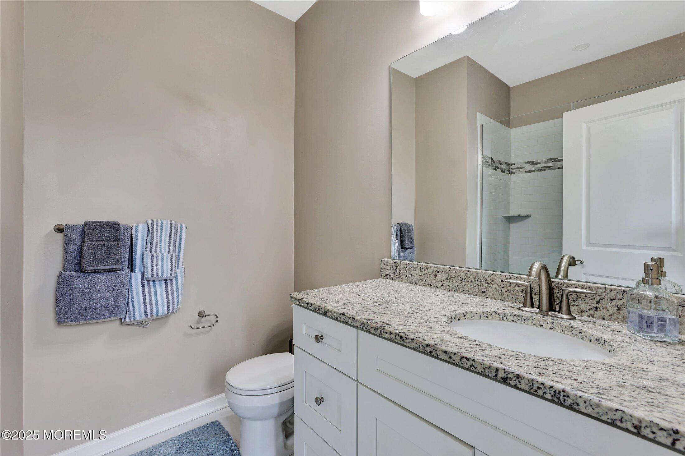 303 Prosper Way, Unit 203 Brick, NJ 08723 - Photo 22 of 36 a bathroom with a granite countertop sink a toilet and a mirror