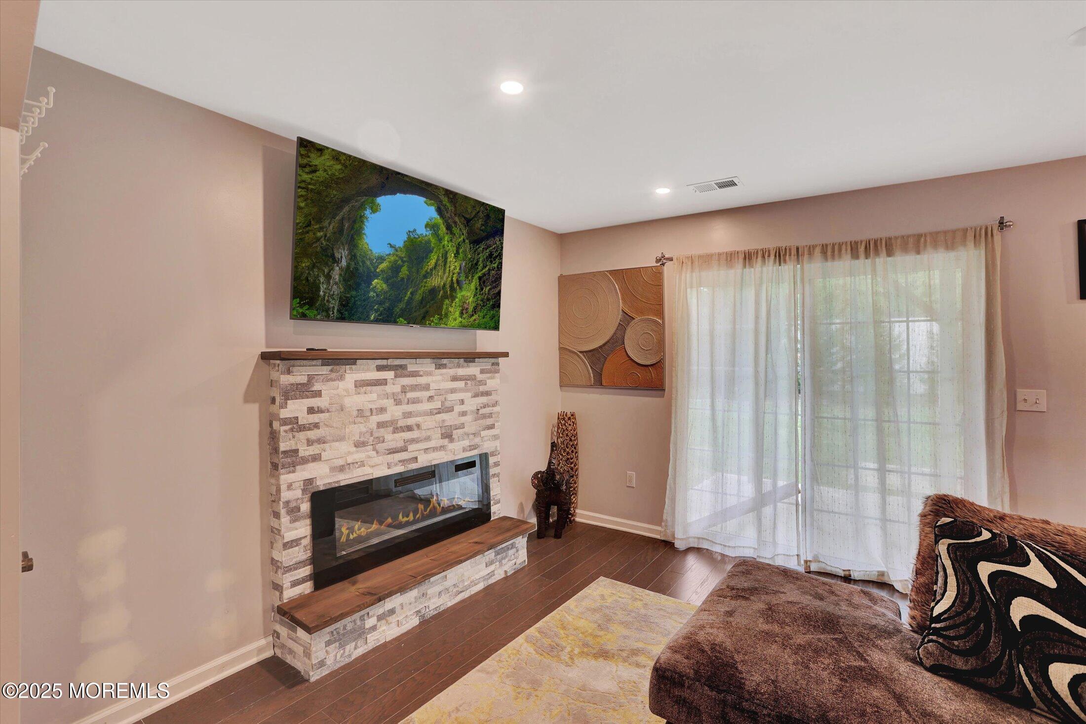 303 Prosper Way, Unit 203 Brick, NJ 08723 - Photo 5 of 36 a living room with furniture a fireplace and a flat screen tv