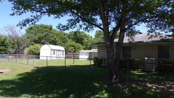 a view of a house with backyard and a tree