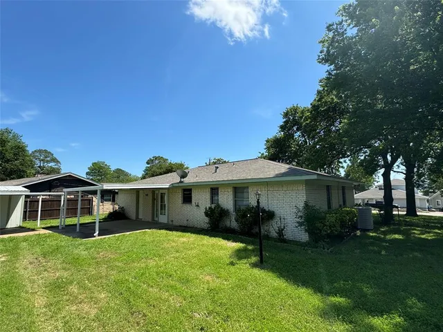 an empty room with wooden floor ceiling fan and windows