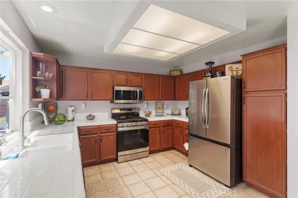 a kitchen with stainless steel appliances granite countertop a refrigerator stove microwave and sink