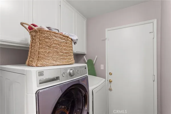 a view of washer and dryer with kitchen in the background