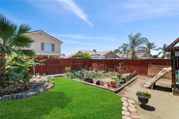 a view of a house with a yard and potted plants