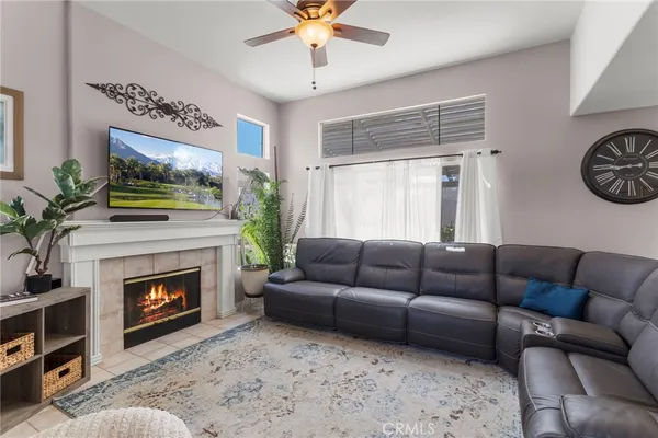 a living room with furniture a fireplace and a flat screen tv