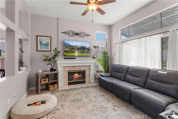 a living room with furniture a flat screen tv and a fireplace