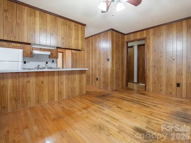 a kitchen with stainless steel appliances granite countertop a refrigerator a sink dishwasher and wooden cabinets with wooden floor