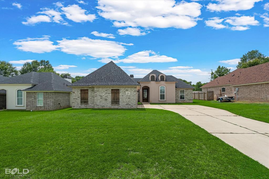 Brick and stucco exterior with multiple gables and a concrete driveway