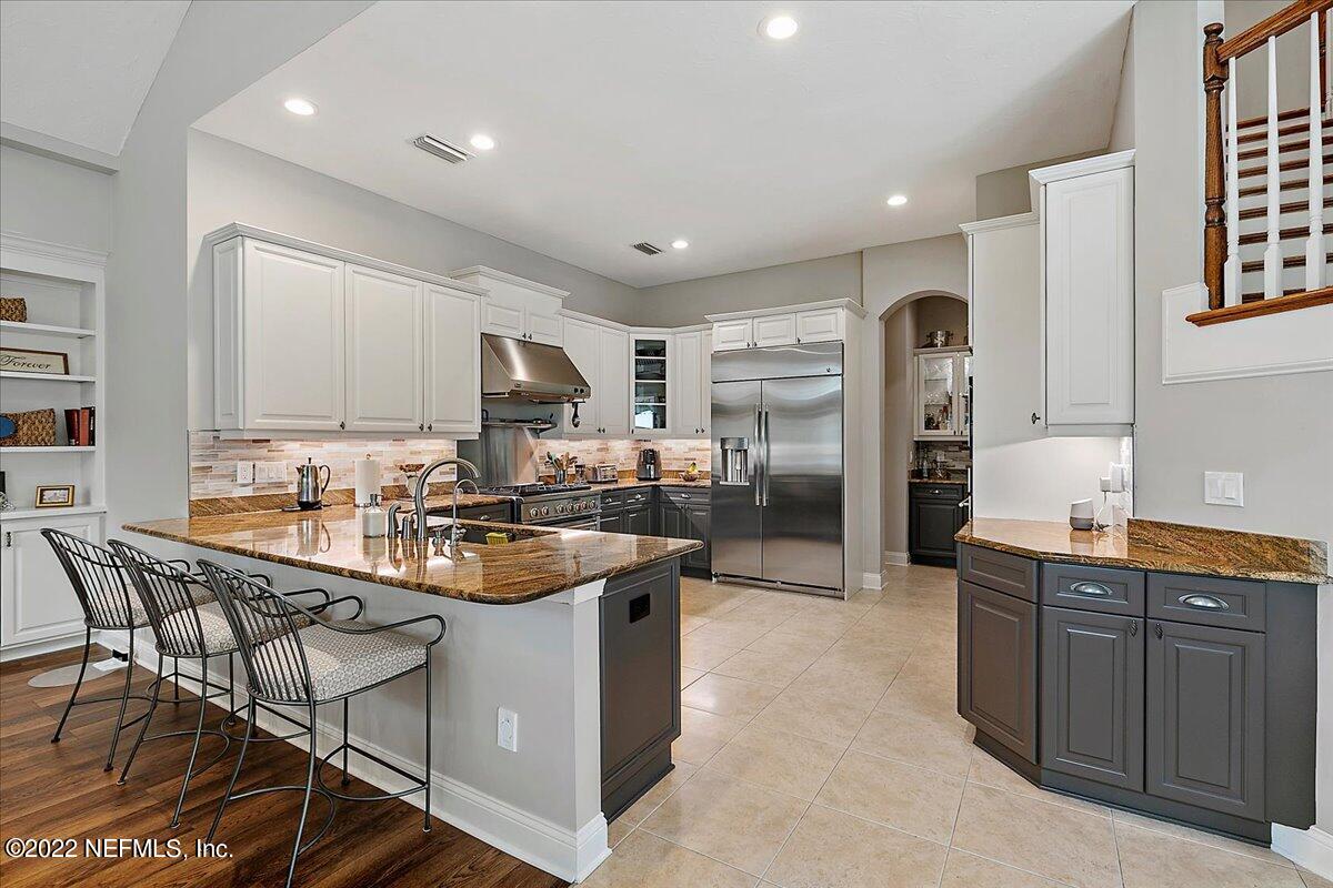 649 Treehouse Circle St. Augustine, FL 32095 - Photo 22 of 71 a kitchen with stainless steel appliances granite countertop a stove a sink a refrigerator and cabinets