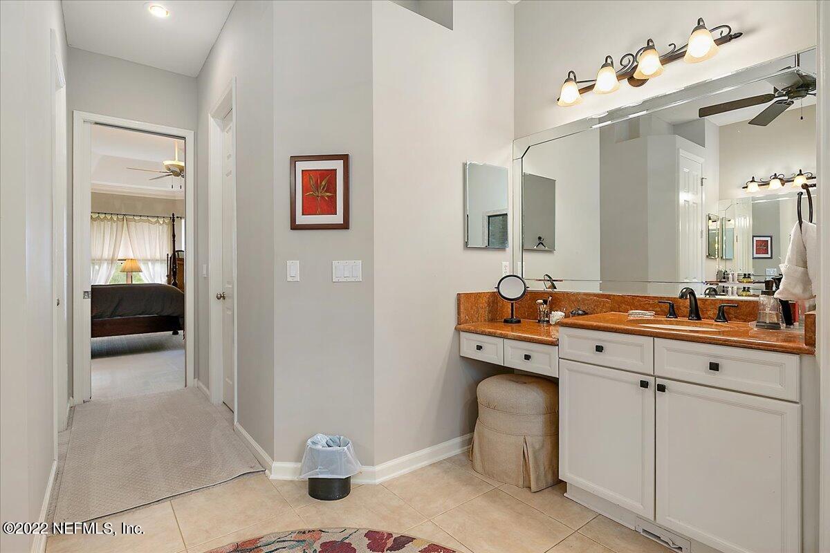 649 Treehouse Circle St. Augustine, FL 32095 - Photo 32 of 71 a en suite bathroom with a sink a mirror and a shower