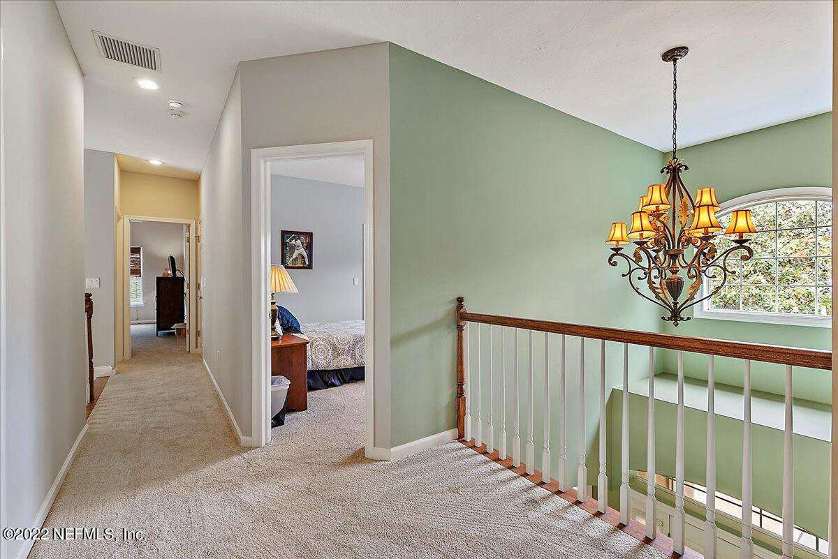 649 Treehouse Circle St. Augustine, FL 32095 - Photo 38 of 71 a view of a hallway with a chandelier