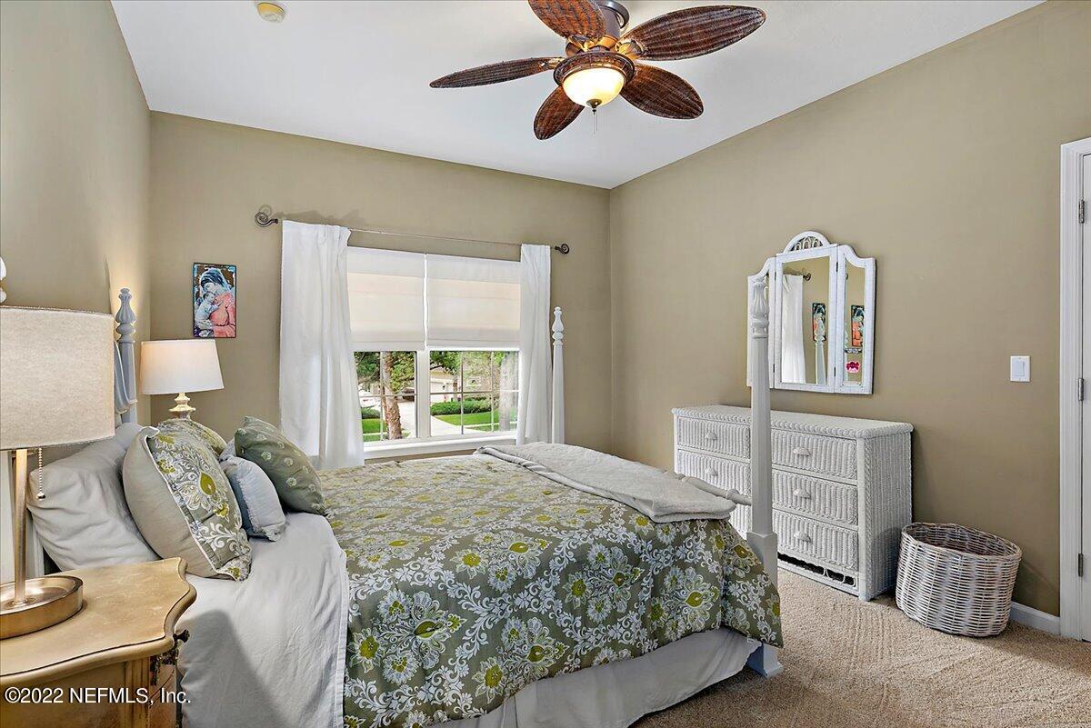 649 Treehouse Circle St. Augustine, FL 32095 - Photo 45 of 71 a bedroom with a bed and dresser with mirror