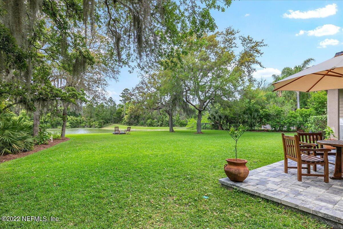 649 Treehouse Circle St. Augustine, FL 32095 - Photo 52 of 71 a view of a backyard with table and chairs under an umbrella