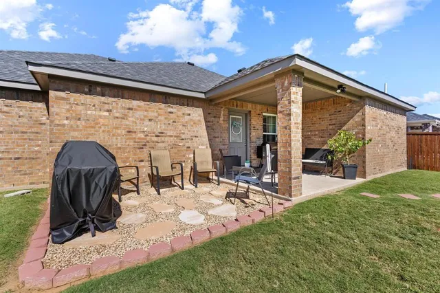 a patio with table and chairs and potted plants