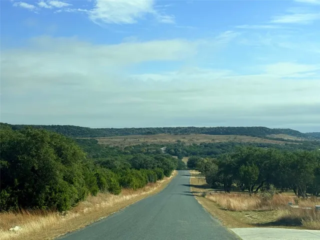 a view of a dry yard with mountains in the background