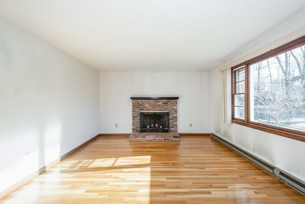 54 Carpenter Road Northbridge, MA 01588 - Photo 9 of 42 a view of an empty room with a fireplace and a window