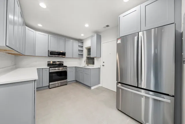 a kitchen with stainless steel appliances a refrigerator sink and microwave