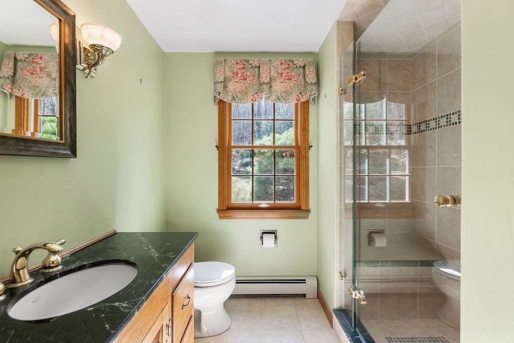 24 Meadow Road Bolton, MA 01740 - Photo 20 of 36 a bathroom with a granite countertop sink toilet a mirror and shower