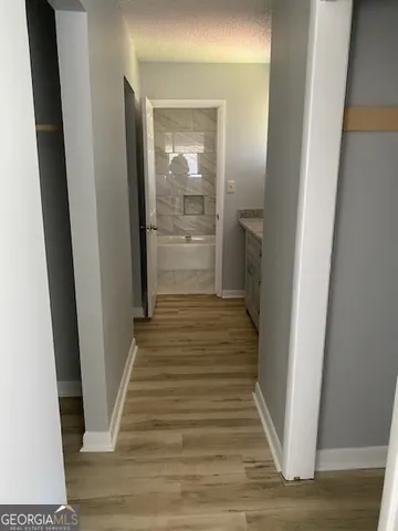 a view of a hallway with wooden floor and staircase