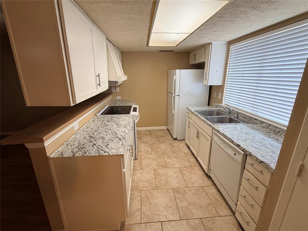 2051 Embassy Way Carrollton, TX 75006 - Photo 7 of 20 a kitchen with stainless steel appliances granite countertop a sink stove and cabinets