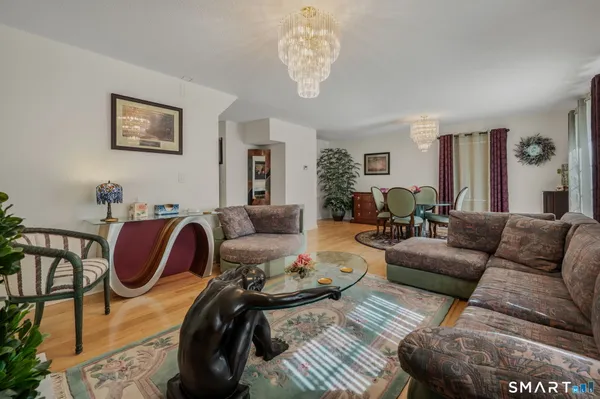 a living room with furniture a flat screen tv and a refrigerator