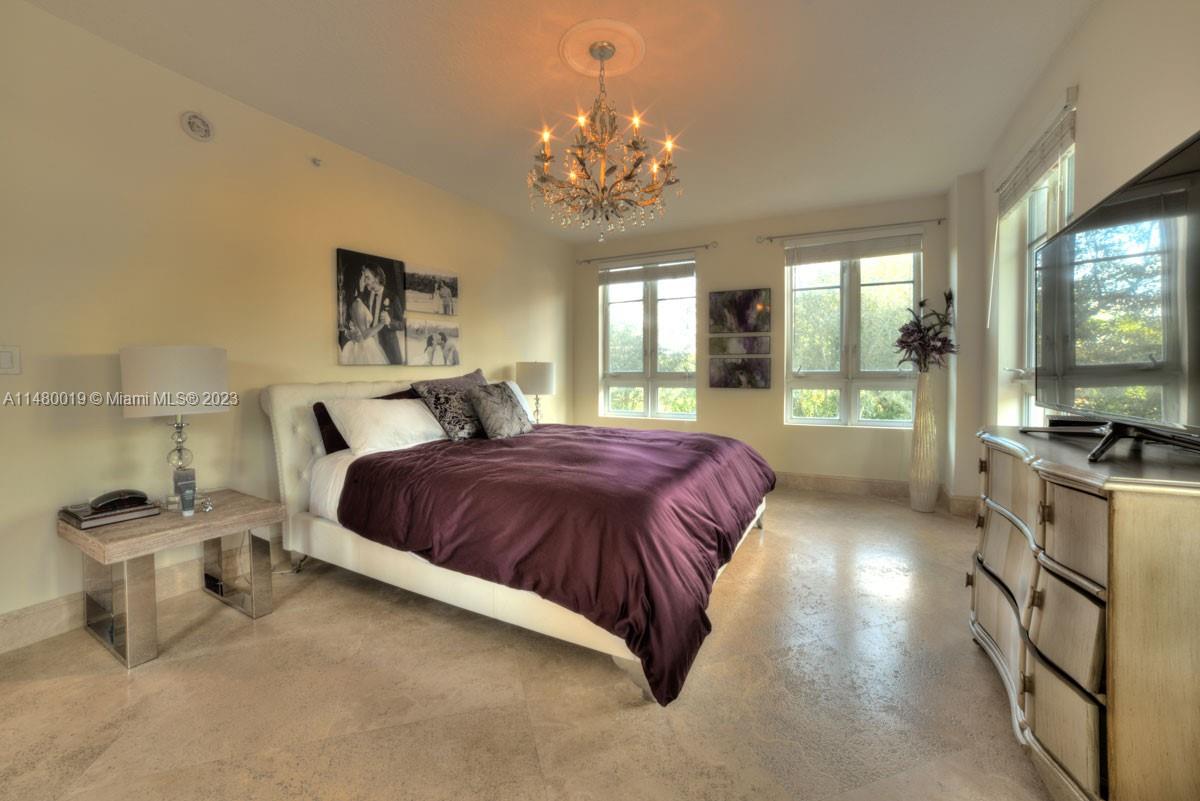 3540 Main Highway, Unit 301 Miami, FL 33133 - Photo 11 of 29 a spacious bedroom with a bed and a large window with the outer view