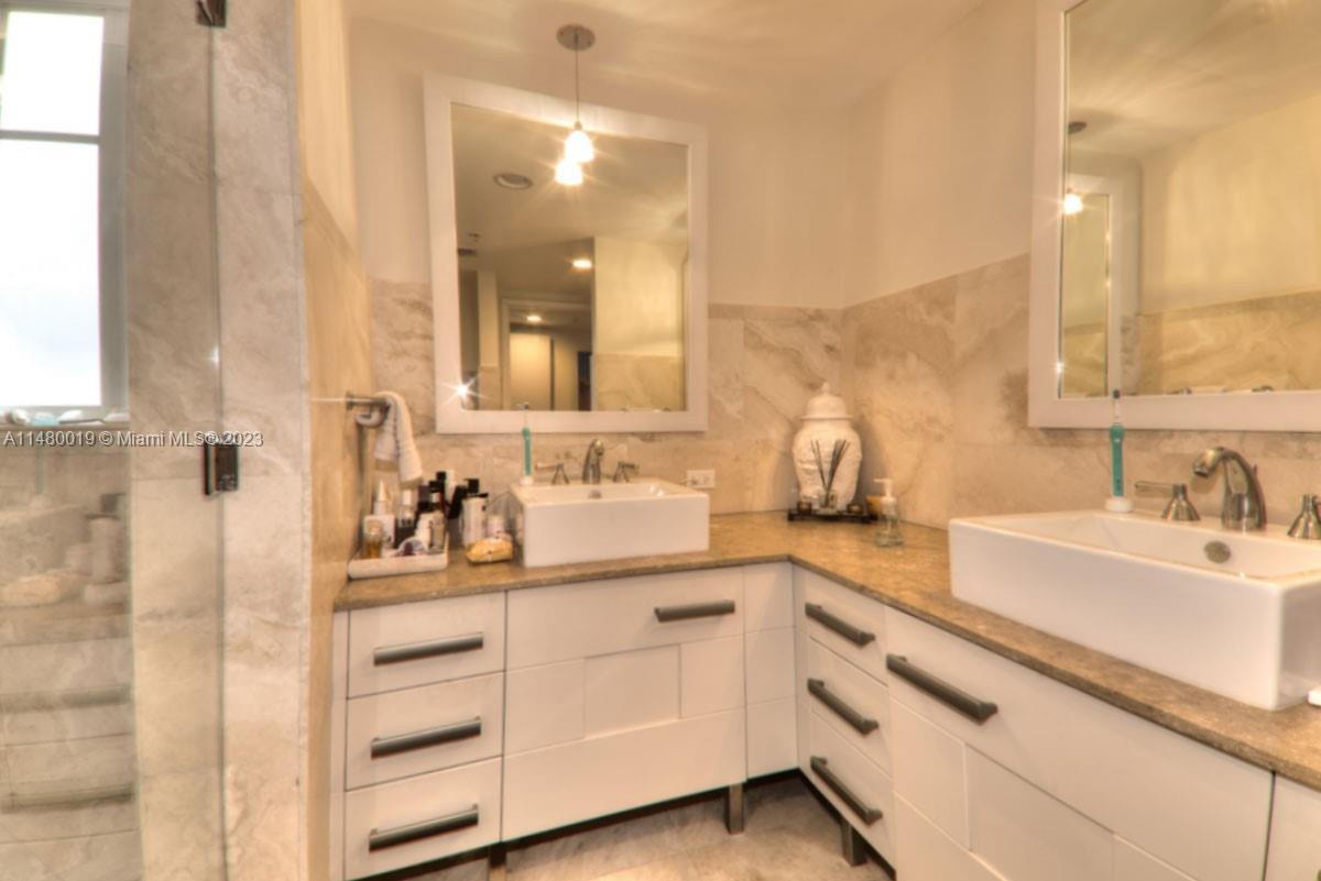 3540 Main Highway, Unit 301 Miami, FL 33133 - Photo 15 of 29 a bathroom with a sink double vanity and a mirror