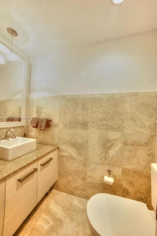 3540 Main Highway, Unit 301 Miami, FL 33133 - Photo 19 of 29 a bathroom with a sink mirror vanity and toilet