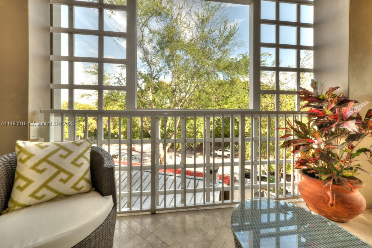 3540 Main Highway, Unit 301 Miami, FL 33133 - Photo 8 of 29 a view of a porch with furniture and floor to ceiling window