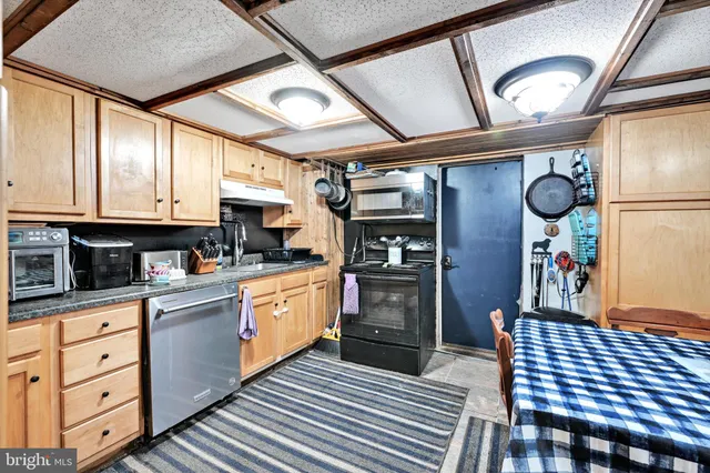 a kitchen with stainless steel appliances granite countertop a refrigerator and wooden cabinets
