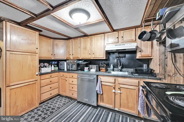 a kitchen with stainless steel appliances granite countertop a stove sink and cabinets