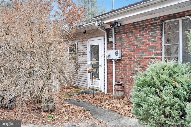 a view of a white house that has a tree on the side of it