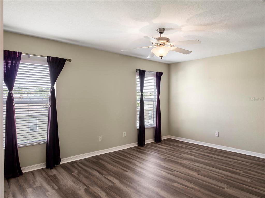 512 Bella Rosa Circle Sanford, FL 32771 - Photo 21 of 31 an empty room with wooden floor chandelier fan and windows