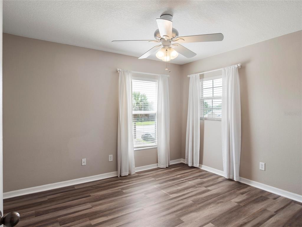 512 Bella Rosa Circle Sanford, FL 32771 - Photo 27 of 31 an empty room with wooden floor chandelier fan and windows