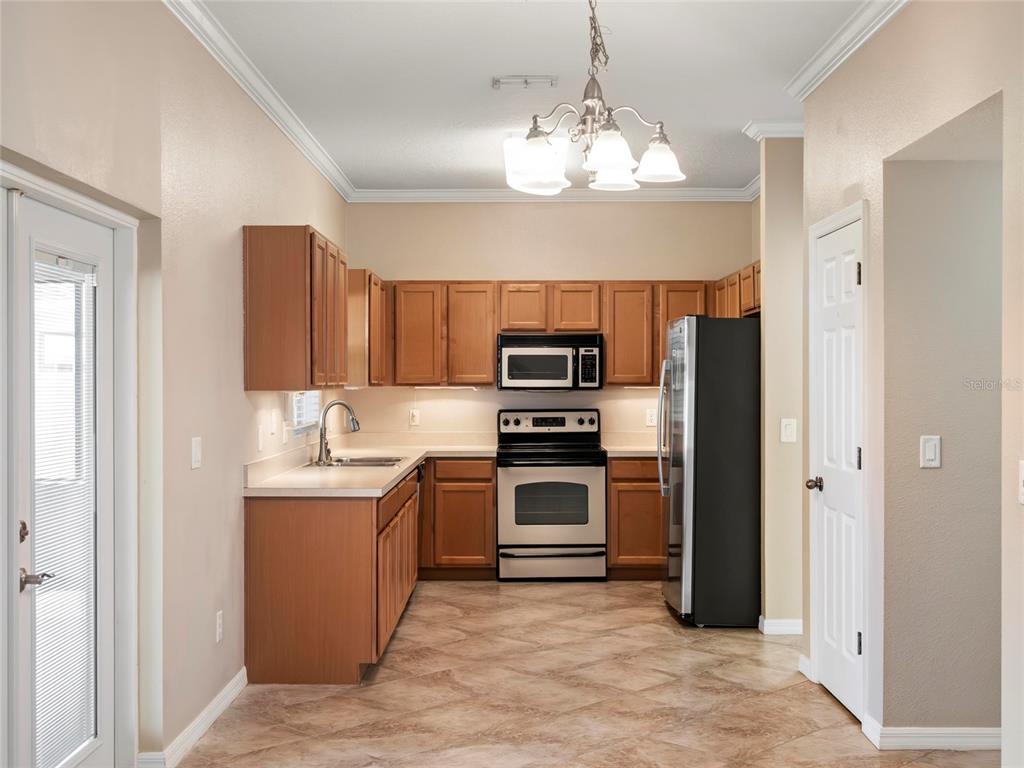 512 Bella Rosa Circle Sanford, FL 32771 - Photo 7 of 31 a kitchen with stainless steel appliances a sink stove and refrigerator
