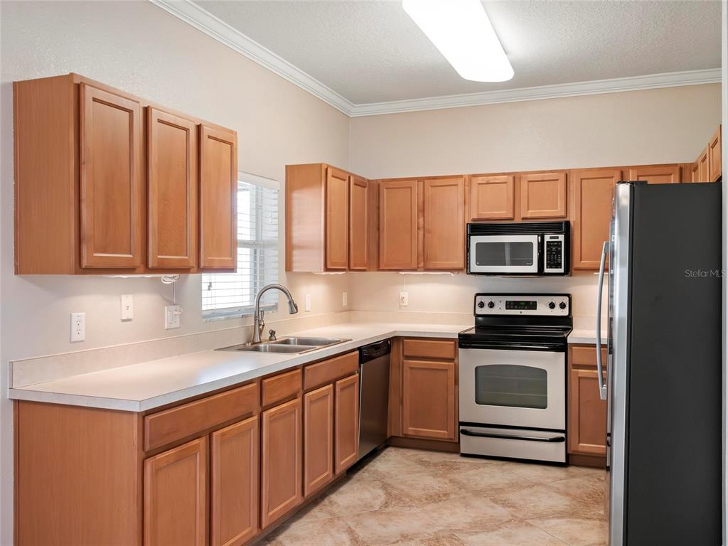 512 Bella Rosa Circle Sanford, FL 32771 - Photo 8 of 31 a kitchen with stainless steel appliances granite countertop a sink stove and refrigerator