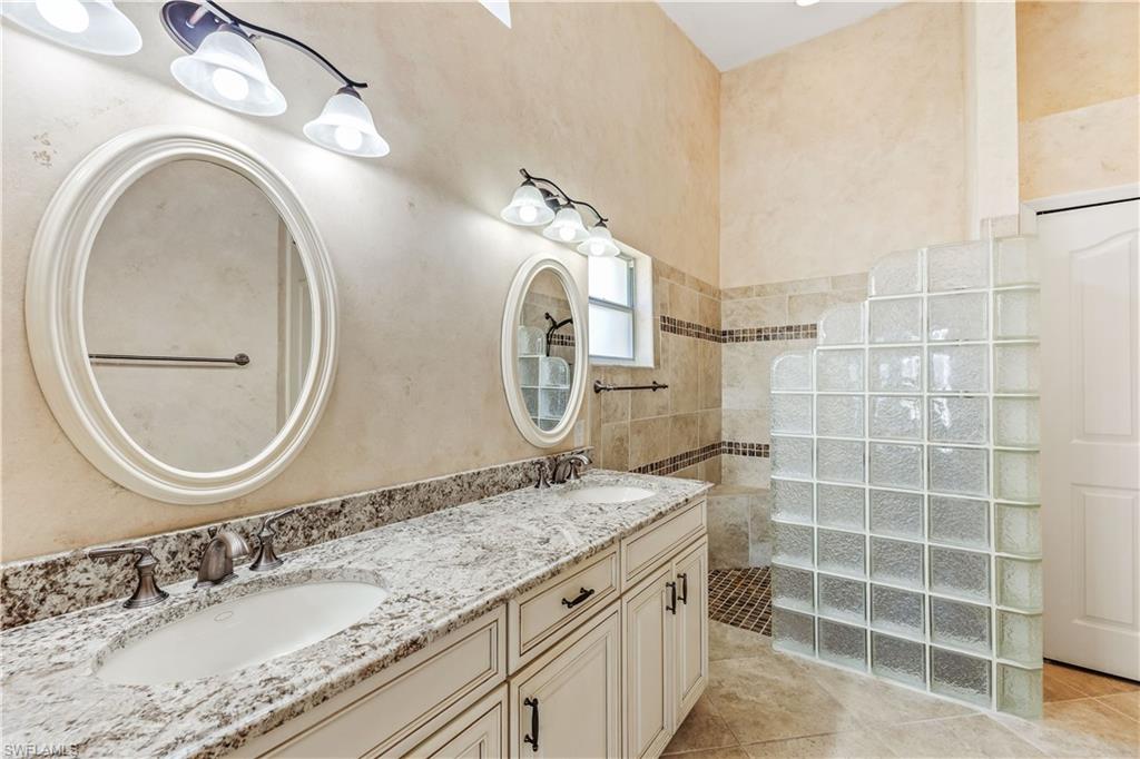 8526 Mustang Drive Naples, FL 34113 - Photo 14 of 24 Bathroom featuring tile patterned flooring, vanity, and walk in shower