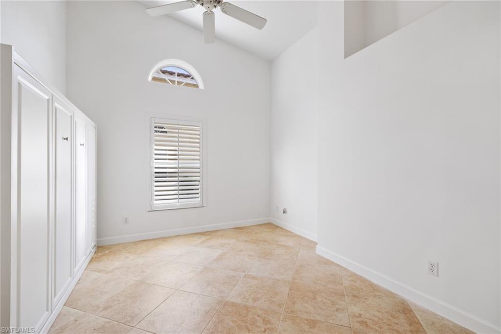 8526 Mustang Drive Naples, FL 34113 - Photo 15 of 24 Unfurnished bedroom with ceiling fan, tile patterned floors, baseboards, and high vaulted ceiling