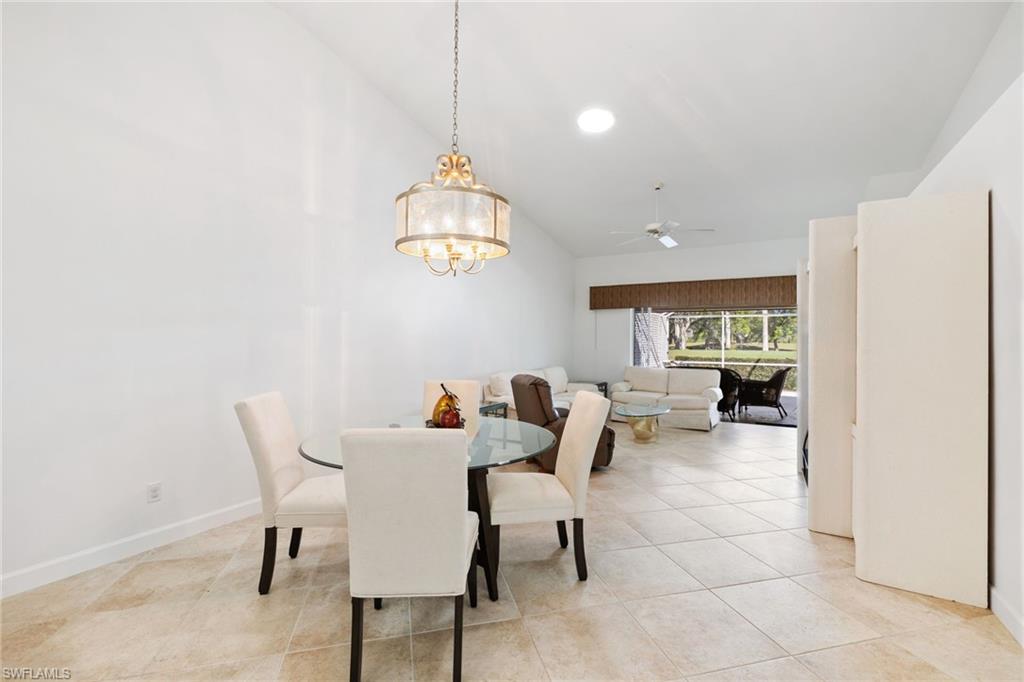 8526 Mustang Drive Naples, FL 34113 - Photo 6 of 24 Dining area with lofted ceiling, light tile patterned flooring, ceiling fan with notable chandelier, and baseboards