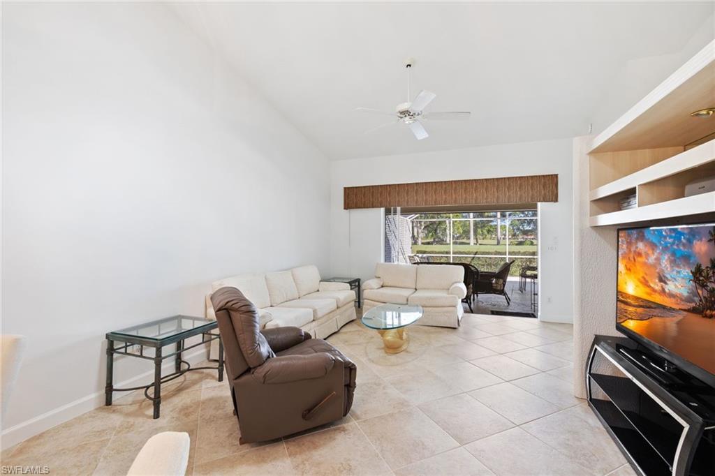 8526 Mustang Drive Naples, FL 34113 - Photo 8 of 24 Living room with light tile patterned flooring, a ceiling fan, baseboards, and high vaulted ceiling