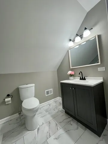 a bathroom with a sink vanity and toilet