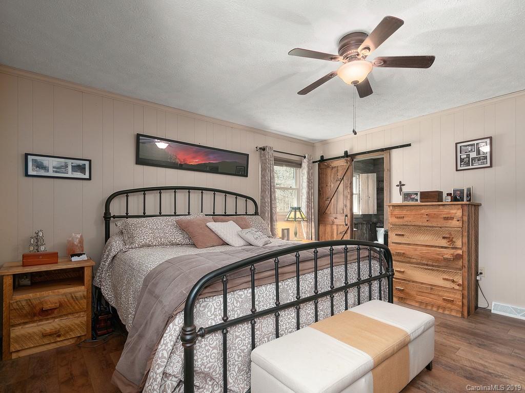 263 Stoney Brook Drive Clyde, NC 28721 - Photo 11 of 25 a bedroom with a bed and a chandelier