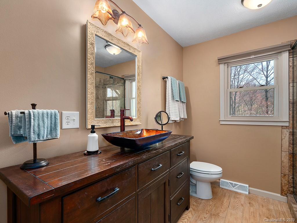 263 Stoney Brook Drive Clyde, NC 28721 - Photo 12 of 25 a bathroom with a toilet a sink and mirror