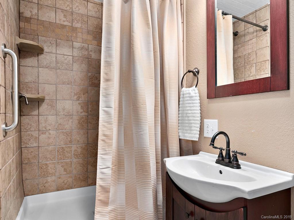 263 Stoney Brook Drive Clyde, NC 28721 - Photo 17 of 25 a bathroom with a sink a mirror and a window