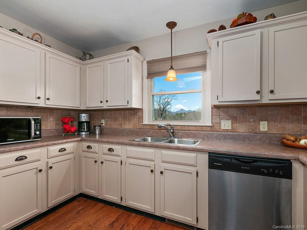 263 Stoney Brook Drive Clyde, NC 28721 - Photo 7 of 25 a kitchen with white cabinets white appliances sink and dishwasher with wooden floor