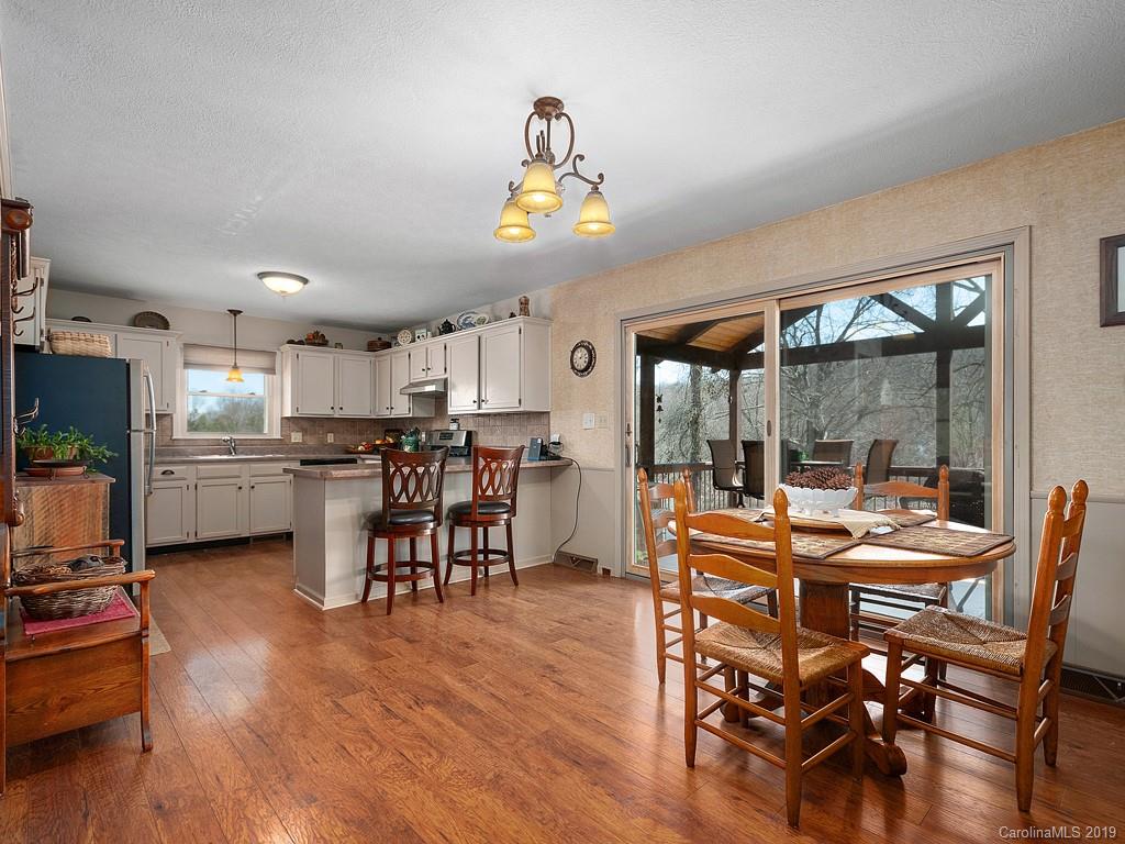 263 Stoney Brook Drive Clyde, NC 28721 - Photo 9 of 25 a room with stainless steel appliances kitchen island granite countertop a dining table chairs and view of living room